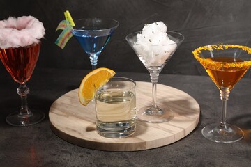 Tasty cotton candy cocktail and other alcoholic drinks in glasses on gray textured table