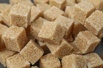 Brown sugar cubes as background, closeup view