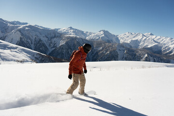 snowboarder freerider riding on an unprepared snow field on board in high mountains - obrazy, fototapety, plakaty