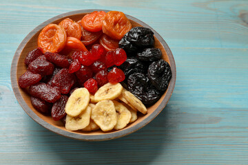 Mix of delicious dried fruits on light blue wooden table