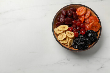 Mix of delicious dried fruits on white marble table, top view