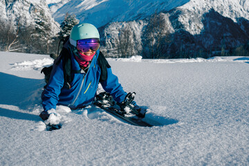 Female snowboarder freerider  hiking in deep snow on ski resort, winter sport outdoor, sunny day in...