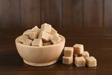 Many brown sugar cubes on wooden table