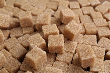 Brown sugar cubes as background, closeup view