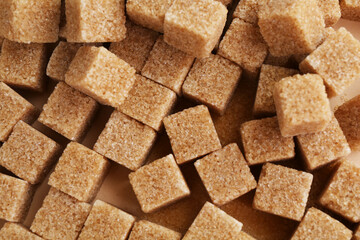 Brown sugar cubes on color background, top view