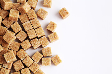 Brown sugar cubes on white background, top view. Space for text