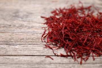 Naklejka premium Aromatic saffron on wooden table, closeup. Space for text