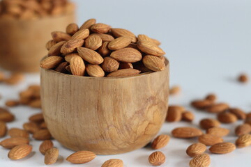 Dry Almonds in wooden bowl. Abundant pile of pealed dry almonds