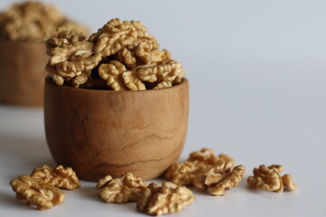 Pristine pile of premium dry walnuts in a wooden bowl, ideal for culinary creations and healthy snacks.