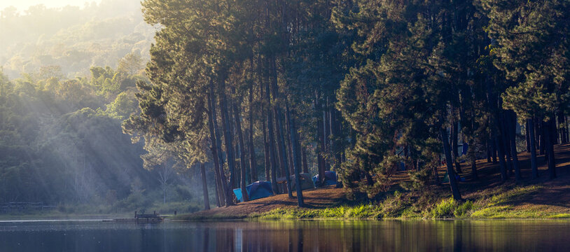 Group of tent for overnight camping with sunrise over the misty mountain and ray of light and campsite of Pang Oung, Mae Hong Son, Thailand
