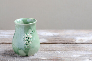 A ceramic jug for mulled vine on wooden table. Christmas celebrations.
