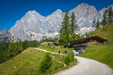 Fototapeta na wymiar Alpine rural road on the slope near wooden houses, Austria