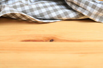 The checkered napkin is lying on a wooden table.