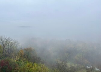 Heavy fog over the forest on an autumn morning. View from above.