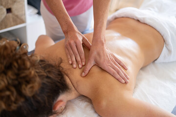 Obraz na płótnie Canvas Masseuse doing massage to woman in salon