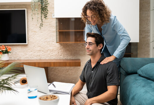 Happy woman giving massage to man during break at home