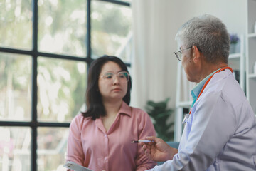 Fototapeta premium Doctor and patient discussing past medical history and also discuss future treatment plans, A patient sits in the office of the doctor who is caring for the patient.