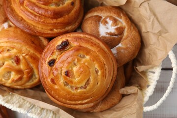 Different delicious rolls on white table, top view. Sweet buns