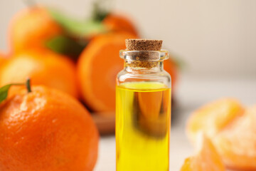 Bottle of tangerine essential oil on blurred background, closeup