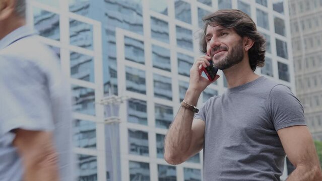 View of a young man with smartphone at daytime with city view landscape in the background. 