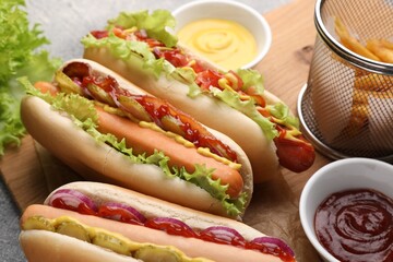 Delicious hot dogs with different toppings served on table, closeup
