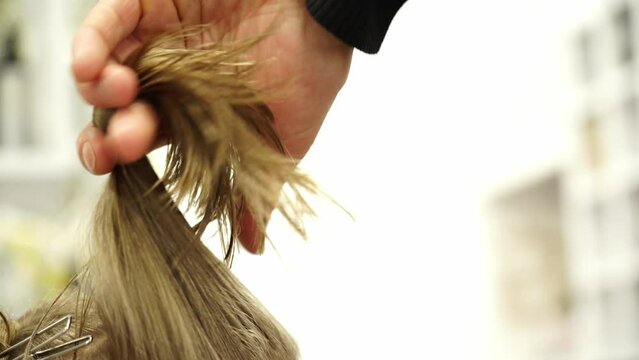 Kyiv, Ukraine - December 22, 2021 - A hairstylist cuts a child's hair. Stylish hairstyle, girl in a hairdresser.