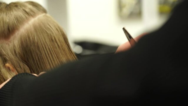 Kyiv, Ukraine - December 22, 2021 - A hairstylist cuts a child's hair. Stylish hairstyle, girl in a hairdresser.
