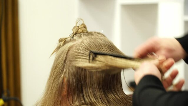 Kyiv, Ukraine - December 22, 2021 - A hairstylist cuts a child's hair. Stylish hairstyle, girl in a hairdresser.