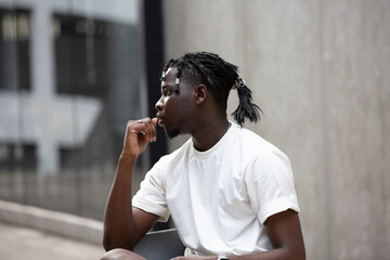 Portrait of young African American male showing short black hair braided hairstyle in the city...