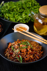 Ramen in a black plate, on a black wooden background