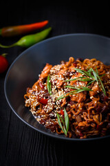 Ramen in a black plate, on a black wooden background