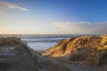 Stormy northern sea at sunset in Denmark. Coastal city Hvide Sande