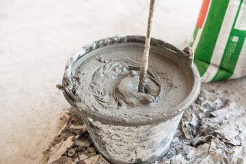 Cement mix in bucket for masonry plaster  - obrazy, fototapety, plakaty