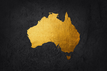 Australia shaped from golden glitter on a black background.