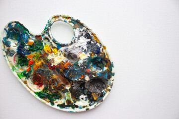 Palette with bright colours on white background. Abstract art. Paint palette with copy space. Drawing hobby. Mix of various colours. Creative design. Inspiration ideas. Vibrant texture.