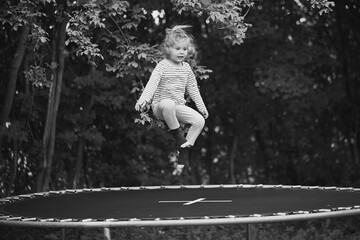 Child jumping on a trampoline in the evening garden in Denmark