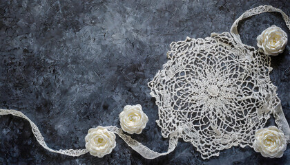 Beautiful white crochet doily on dark marble table with green white roses.  Lace Vintage background Copy space. - obrazy, fototapety, plakaty