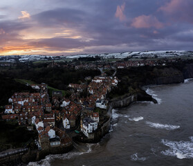 Robin Hoods Bay in snow sunset tide in