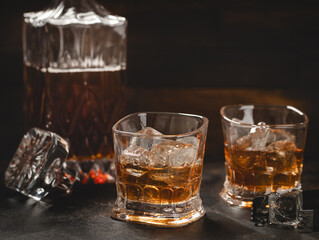 Glasses of whiskey with ice and decanter