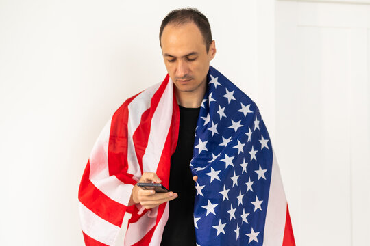 Young man holding an American flag on white background