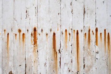 Une vieille porte en bois avec de la peinture blanche écaillée et des clous rouillés - obrazy, fototapety, plakaty