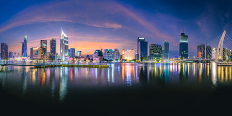 Very beautiful sunset panorama over buildings along the Saigon River in Ho Chi Minh City, Vietnam. - obrazy, fototapety, plakaty