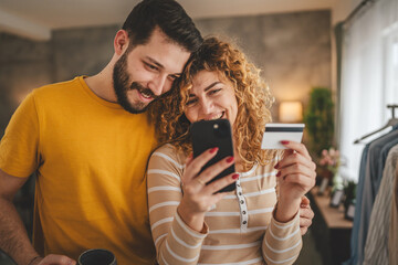 adult happy couple man and woman shopping online hold credit card