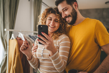 adult happy couple man and woman shopping online hold credit card