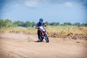 Enduro bike racer riding on dirt motocross road