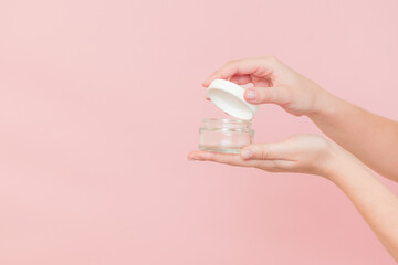 Glass clear cosmetics jar for face or skin cream in hand. Package for cosmetic beauty product, luxury makeup container