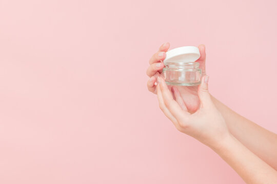 Glass clear cosmetics jar for face or skin cream in hand. Package for cosmetic beauty product, luxury makeup container
