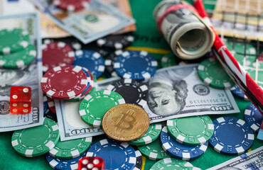 colored poker chips scattered with a roll of US dollars isolated on a black background. Gambling....