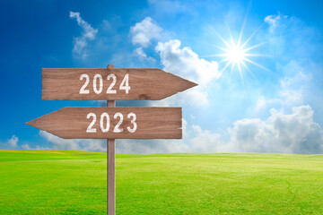 Road signs indicate the path to the new year 2024 and the old year 2023 on a blue sky, creative idea. Choose a new road, concept. Change for the better.