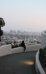 Los Angeles, California, USA; October 24 2023: Young single lady watching Los Angeles skyline from...